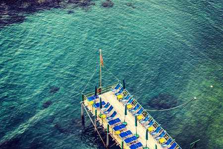 Beach chairs and parasols on a wooden pier in Sorrento coast. Campania, Italyの写真素材