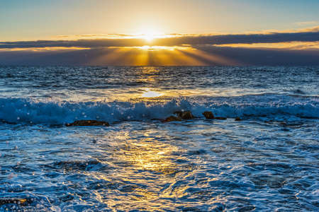 Small wave under a shining sun at sunset. Sardinia, Italyの写真素材