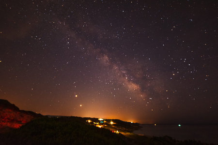 Milky way over Sardinia shoreline at night, Italy