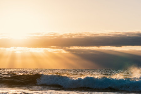 Sun rays and small clouds at sunset. Sardinia, Italy