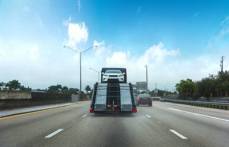Car transporter seen from behind on a Miami freeway. Southern Florida, USAの写真素材