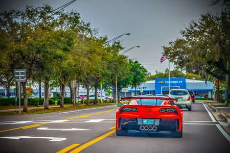 USA - February 24, 2019: Red Corvette seen from behind with dealership on the backgroundのeditorial素材