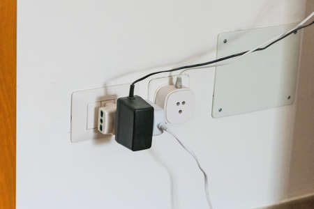 Plugs and sockets on an Italian domestic white wallの写真素材