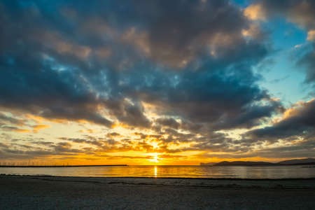 Dramatic sky over Alghero sandy shore at sunset. Sardinia, Italyの写真素材