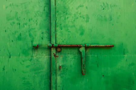 Close up of a latch on a green metal doorの写真素材