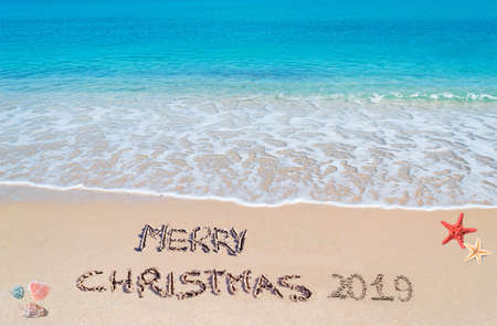 "merry christmas 2019" written on a tropical beachの写真素材