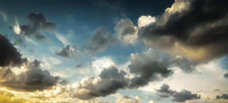Dark clouds and bright sun at sunsetの写真素材
