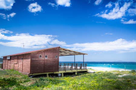 Wooden beach restaurant under a cloudy sky in Sardinia, Italyの写真素材