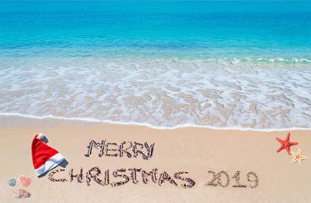 santa hat and "merry Christmas 2019" written on a tropical beachの写真素材