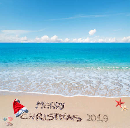 santa hat and "merry Christmas 2019" written on a tropical beachの写真素材