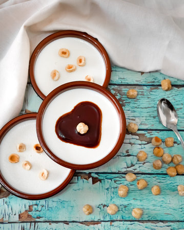 Flat lay of Italian dessert panna cotta with hazelnuts and caramel