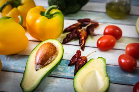 Avocado and other vegetables on a wooden tableの写真素材