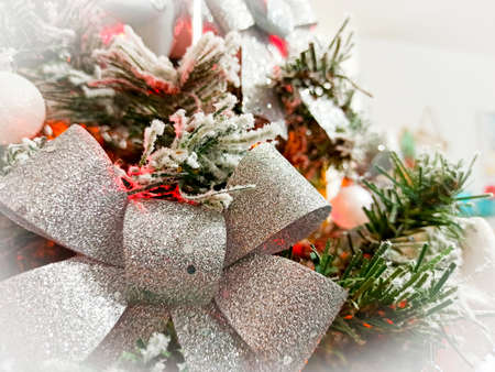 Close up of a silver bow and snowy branches of a Christmas treeの写真素材