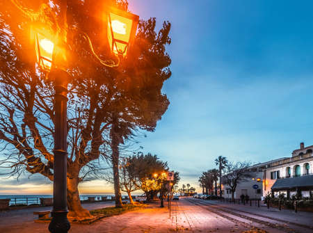 Lampposts in Alghero seafront at sunset. Sardinia, Italyの写真素材