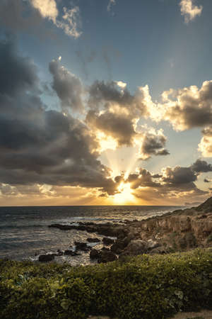 Dark clouds over Alghero rocky shore at sunset. Sardinia, Italyの写真素材