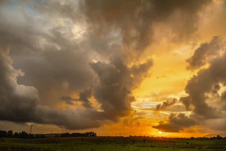 Dramatic sky over a green field at sunset. Sardinia, Italyの写真素材