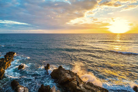 Sun shining over Alghero rocky shore at sunset. Sardinia, Italyの写真素材