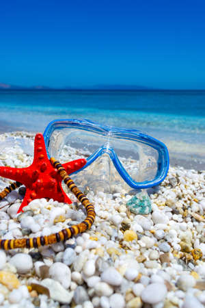 Diving mask, starfish ans necklace on pebbles in sumerの写真素材