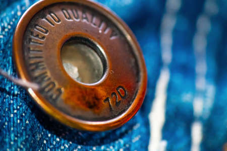 Extreme close up of a metal button on a pair of jeansの写真素材