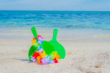 Rackets and hawaiian necklace on the beach in summerの写真素材