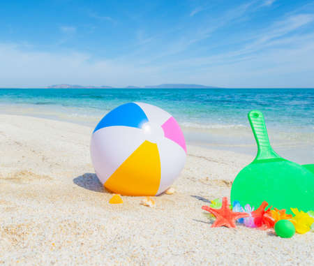 Beach ball and rackets on the sand in the summertimeの写真素材