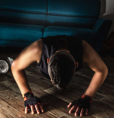 Front view of a man doing push ups during home workoutの写真素材