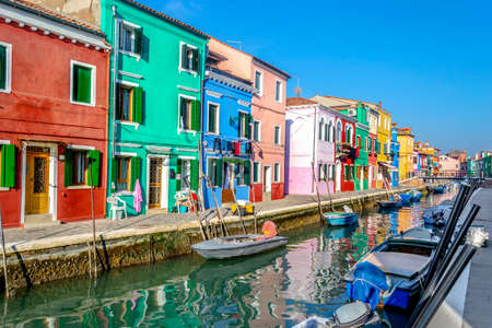 Colorful houses by a narrow canal in Burano, Italyの写真素材
