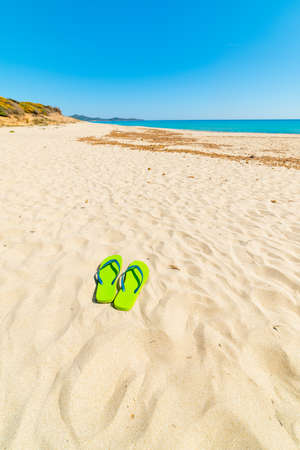 Flip flops on a white beach in summer. Sardinia, Italyの写真素材
