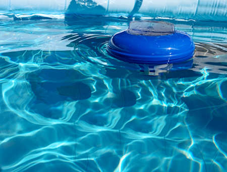 Chlorine dispenser floating on a swimming pool on a sunny day. Chlorine dispensers are used to disinfect swimming pool waterの写真素材