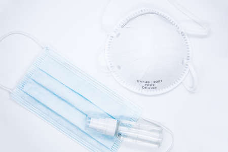 Virus protective masks and hand sanitizer on white backgroundの写真素材