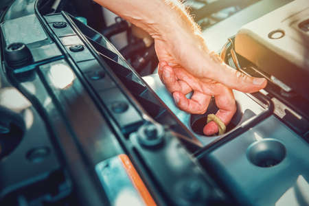 Close up of a man checking engine oil dipstick of a modern carの写真素材