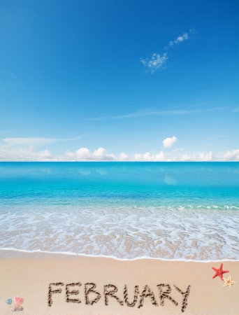 February written on a tropical beach under a blue skyの写真素材