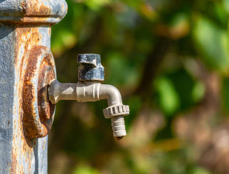 Close up of a fountain tap on a green backgroundの写真素材