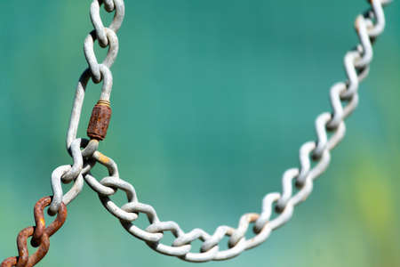 Close up of a metal chain on a green backgroundの写真素材