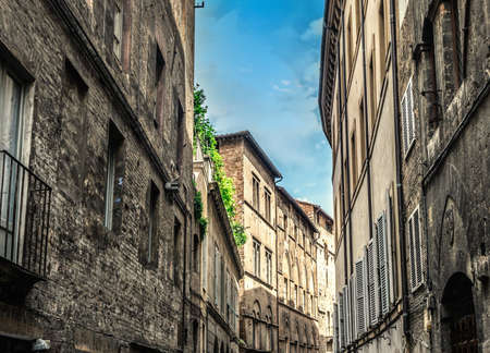 Ancient buildings in a narrow street in Siena. Tuscany, Italyの写真素材