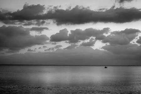 Fisherman alone in the sea at sunset. Sardinia, Italy. Black and white effectの写真素材