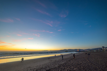 People in Santa Monica shore at sunset. California, USA