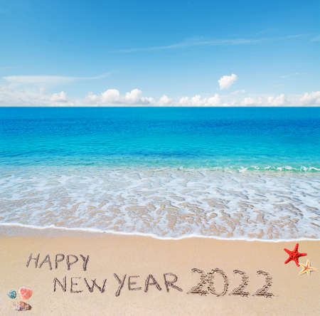 "happy new year 2022" written on a tropical beachの写真素材
