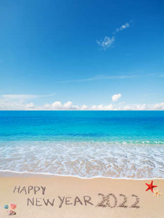 "happy new year 2022" written on a tropical beachの写真素材