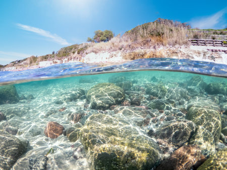 Sand and rocks in La Speranza seabed in split underwater view. Sardinia, Italyの写真素材