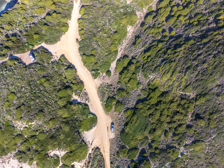Aerial view of a man by a car on a dirt road in Sardinia, Italyの写真素材