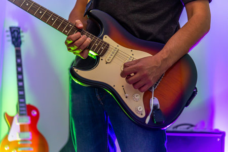 Close up of a guitar player bending a note with an electric guitar and an amplifier on the backgroundの写真素材
