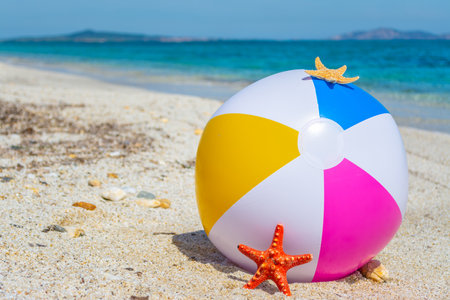 Beach ball by the sea in summerの写真素材