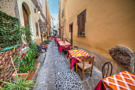 Castelsardo, ITA - August 31, 2016: Tables and chairs in a picturesque alley in Castelsardo, Italyのeditorial素材