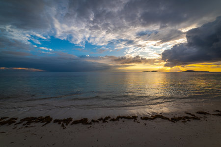 Dramatic sky over Grande Anse beach at sunset. Praslin island, Seychellesの写真素材