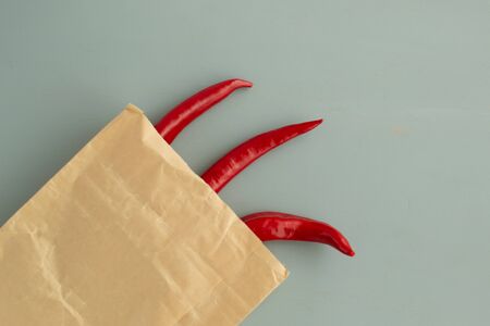 Ugly vegetables. Red pepper in a paper bag on a gray background. top viev The form does not affect the taste, ugly vegetables are tasty and sweetly just as normal.の写真素材