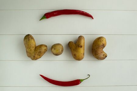 Ugly vegetables. Potatoes on a white wooden background. top viev The form does not affect the taste, ugly vegetables are tasty and sweetly just as normal.の写真素材