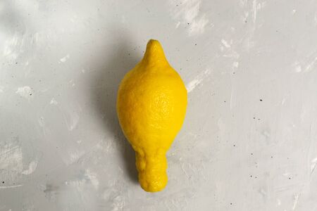 Ugly lemon on a gray background. Copy space. Close-up. Horizontal orientation. The concept of ugly vegetables and fruits.の写真素材