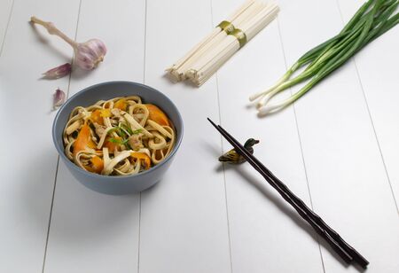 Udon noodles with chicken, carrots and green onions and fresh ingredients on a white background. Japanese kitchen.の写真素材