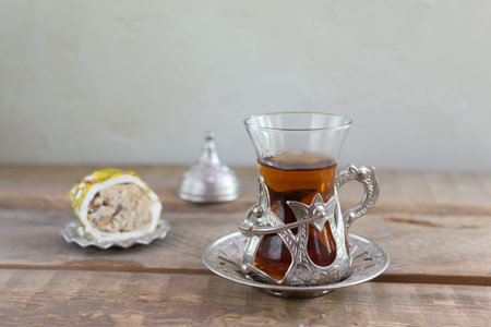 Delicious Turkish tea with a traditional glass cup with a piece of Turkish delight on a wooden table. Copy space. Horizontal orientation.の写真素材